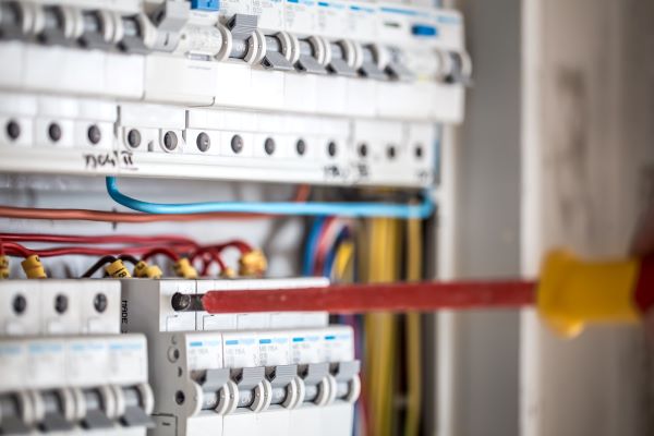 man electrical technician working switchboard with fuses installation connection electrical equipment close up
